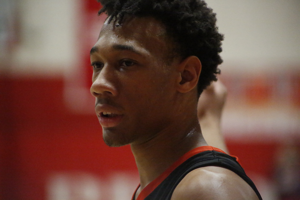 A close up of a basketball player with his hair in the air