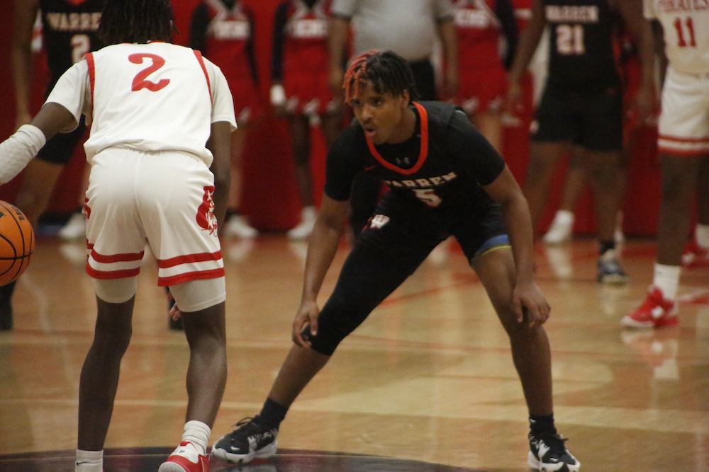 A young man is playing basketball on the court.