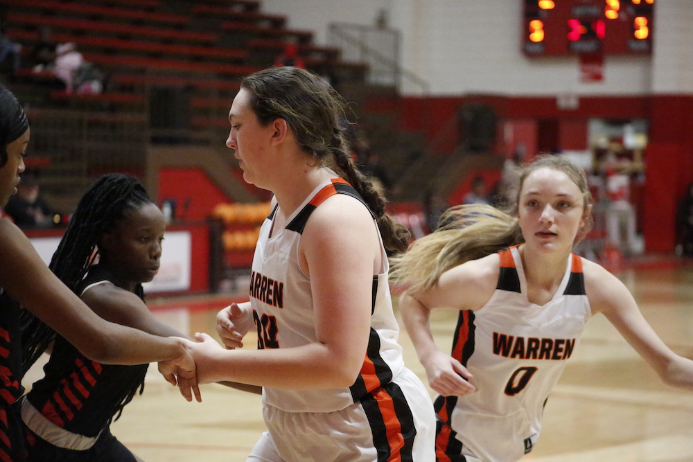 A group of girls playing basketball on the court.