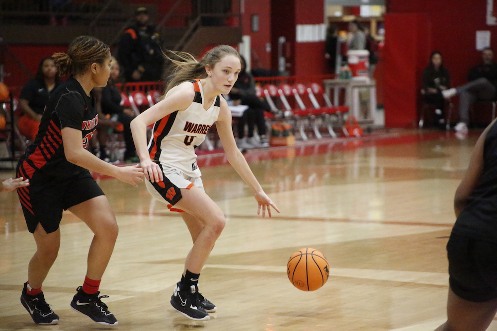Two girls playing basketball on a court