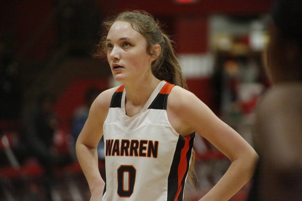 A woman in white and black basketball uniform.