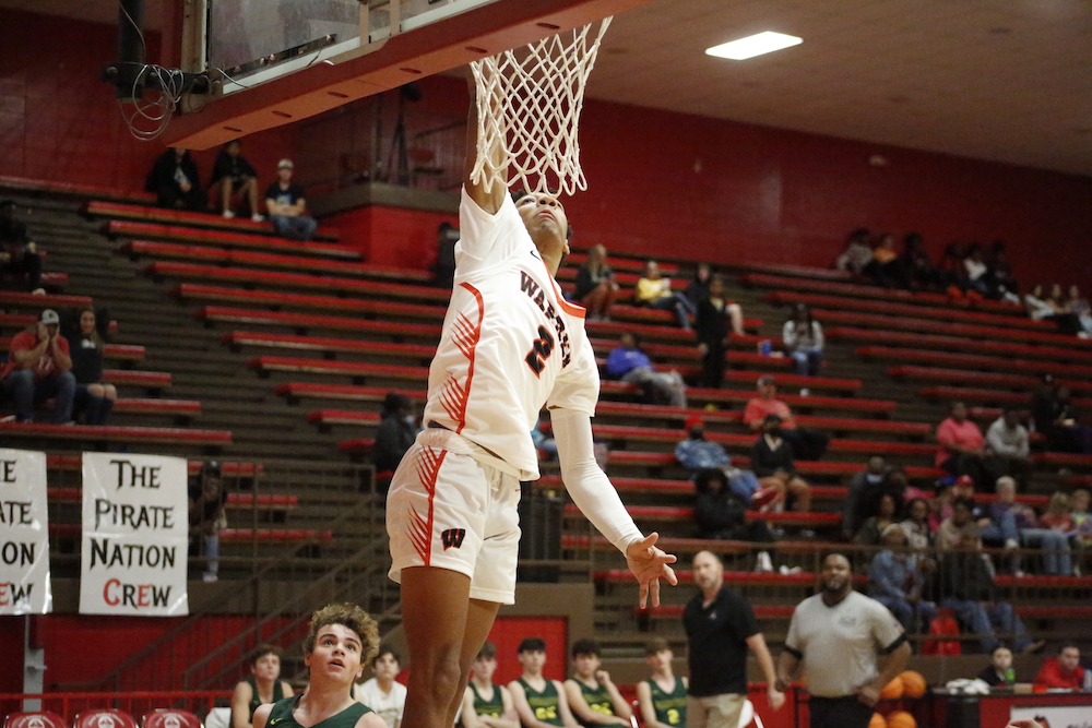 A man that is jumping in the air with a basketball.