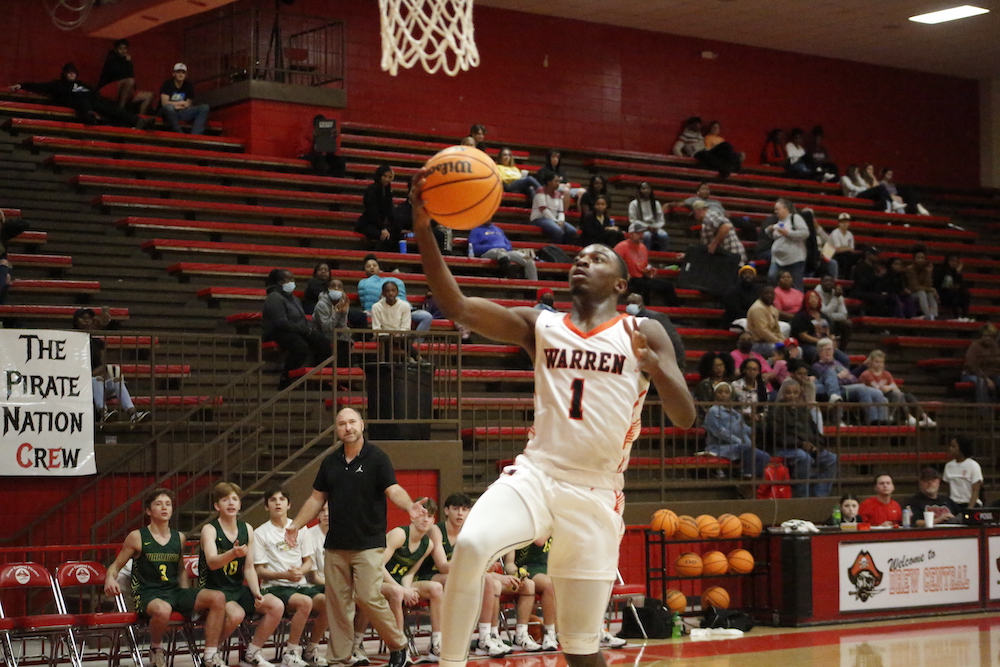 A man in white and black basketball uniform playing basketball.