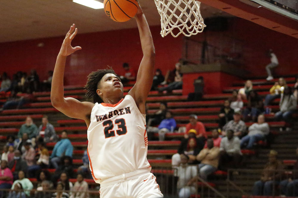 A man in white and black basketball uniform playing basket ball.