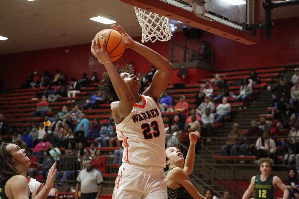 A man that is jumping in the air with a basketball.