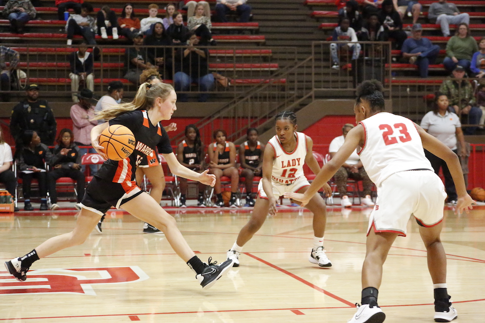 A group of people playing basketball on a court.