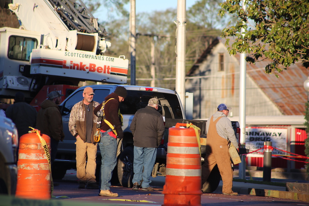 A group of construction workers standing around on the side walk