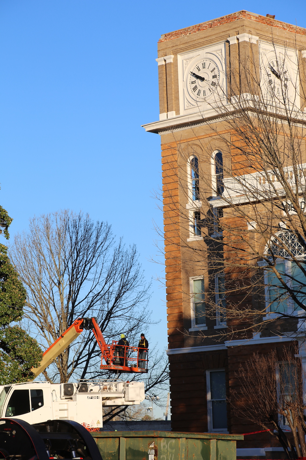 A man on a crane working on the side of a building.