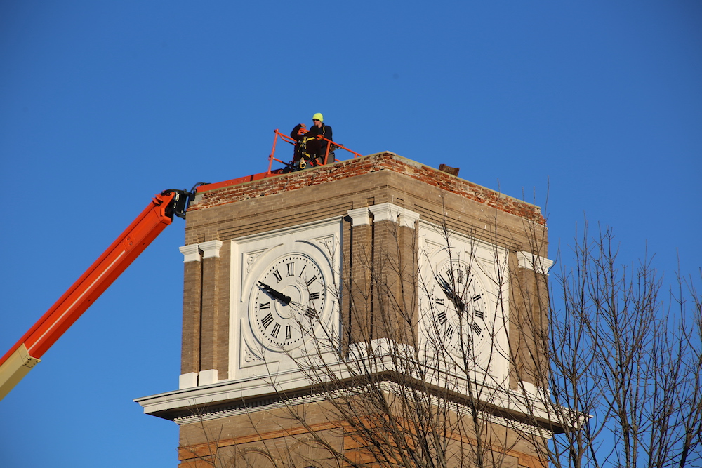 A man standing on top of a clock tower.