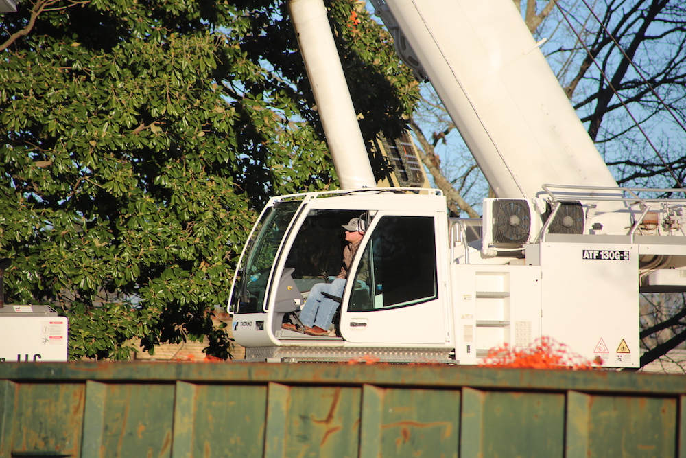 A man sitting in the cab of a crane.