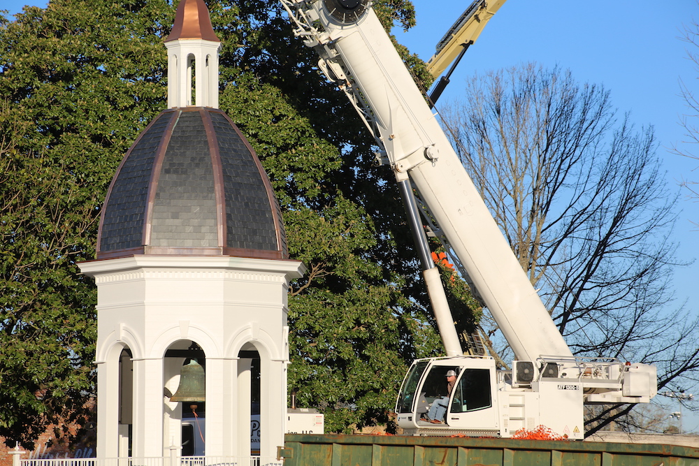 A crane is being used to lift the roof of a church.