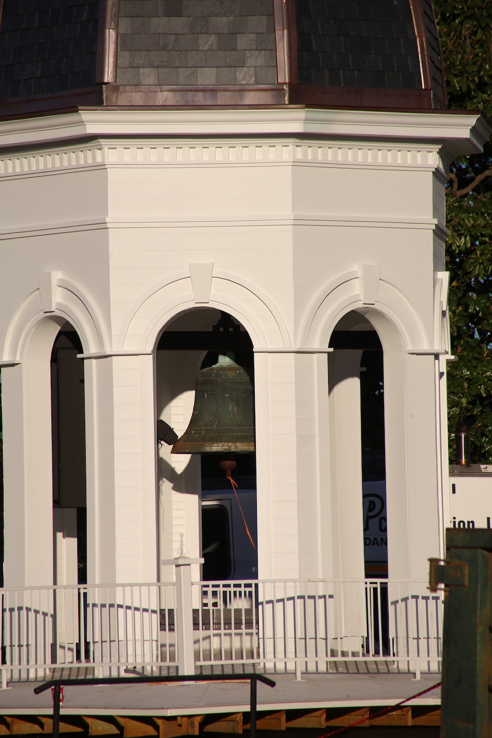 A bell is in the middle of a building.