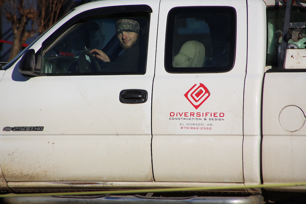 A man sitting in the drivers seat of a white truck.