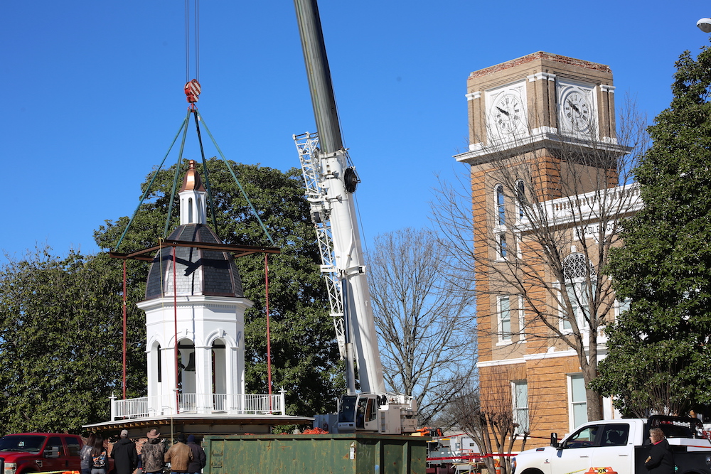 A crane is lifting up the clock tower.
