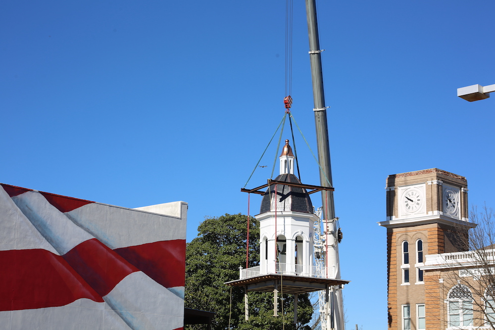 A crane is lifting up the clock tower.
