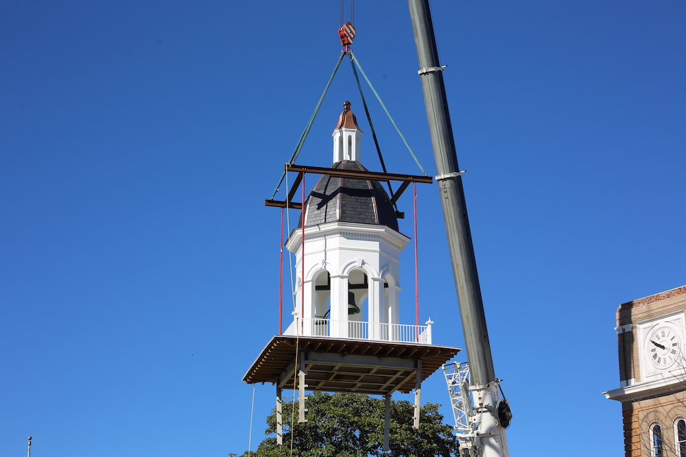 A crane is lifting up the clock tower.