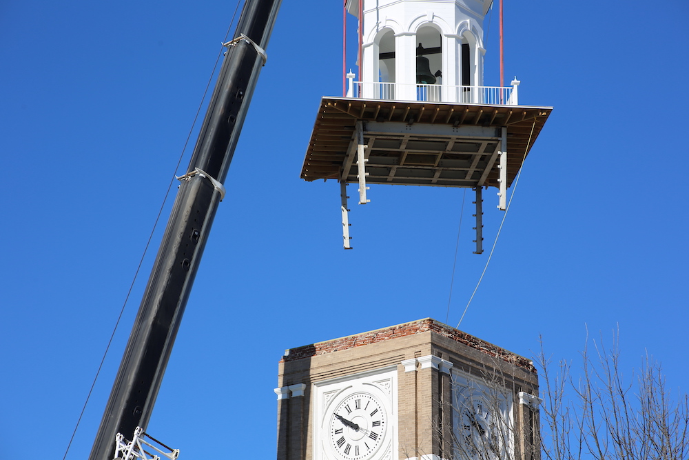 A crane is lifting up the clock tower.