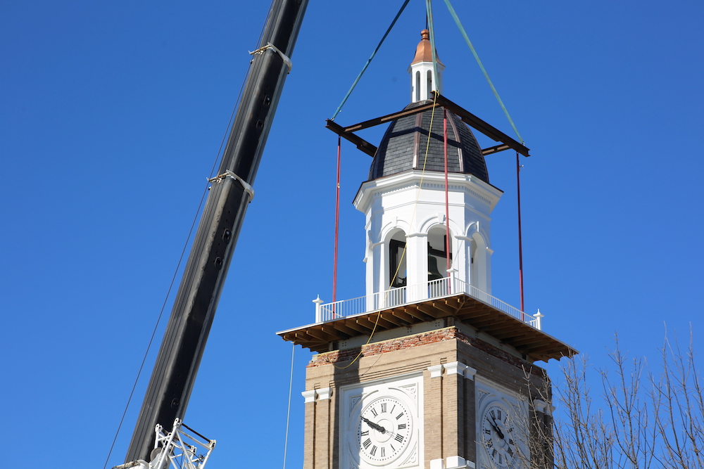 A crane is lifting the clock tower.