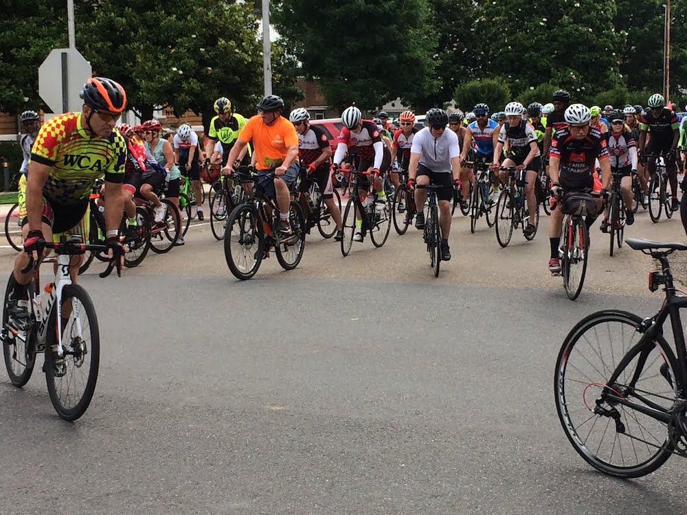 A group of people riding bikes on the street.