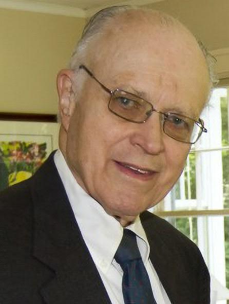 A man in suit and tie smiling for the camera.