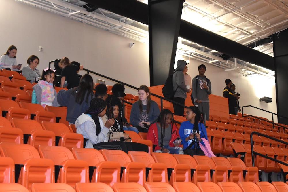 A group of people sitting in an orange stadium.