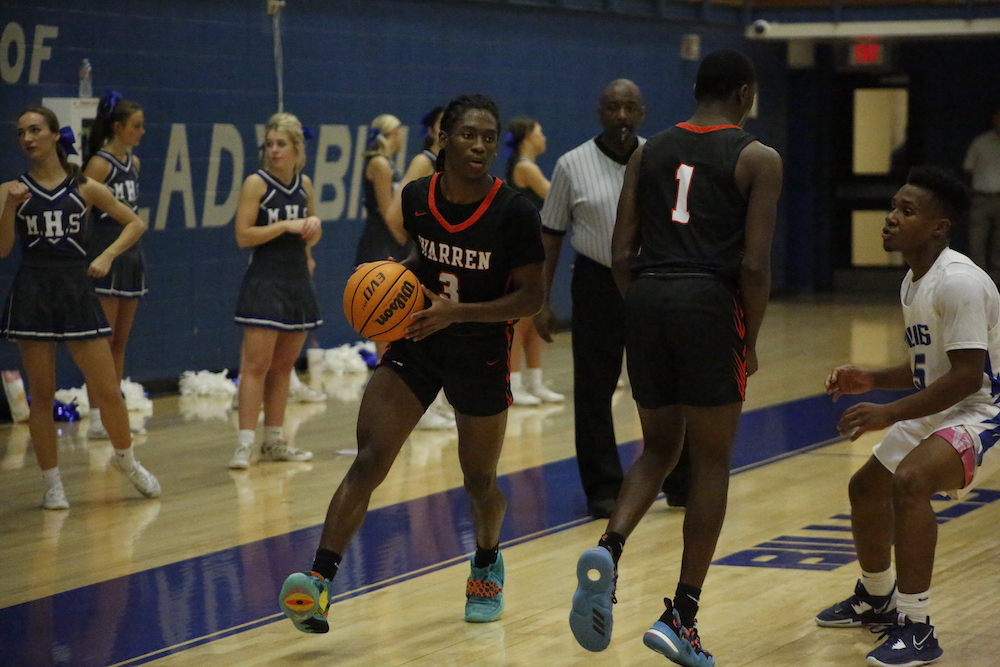 A group of people playing basketball on a court.