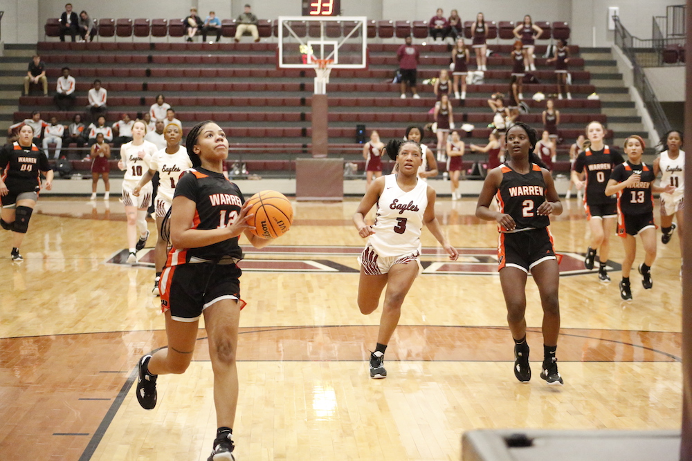 A group of women playing basketball on a court.