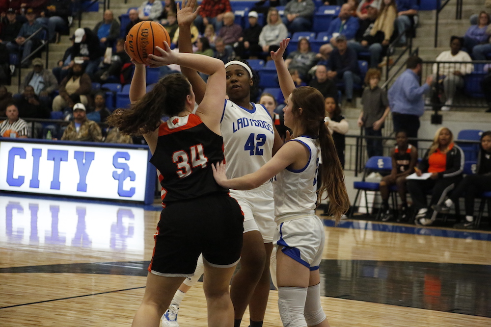 A group of women playing basketball on a court.