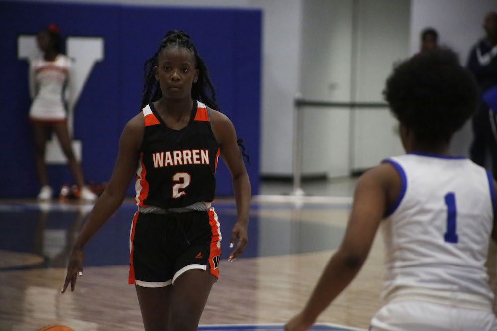 A young girl playing basketball on the court.