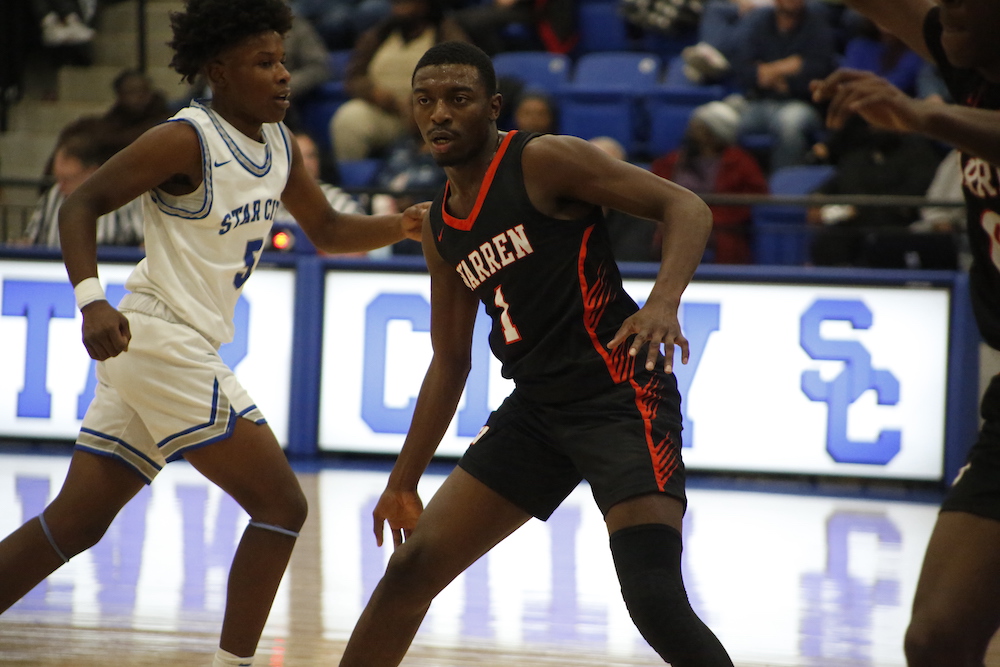 A basketball player is playing on the court