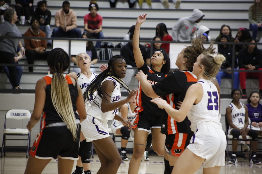 A group of girls playing basketball on the court