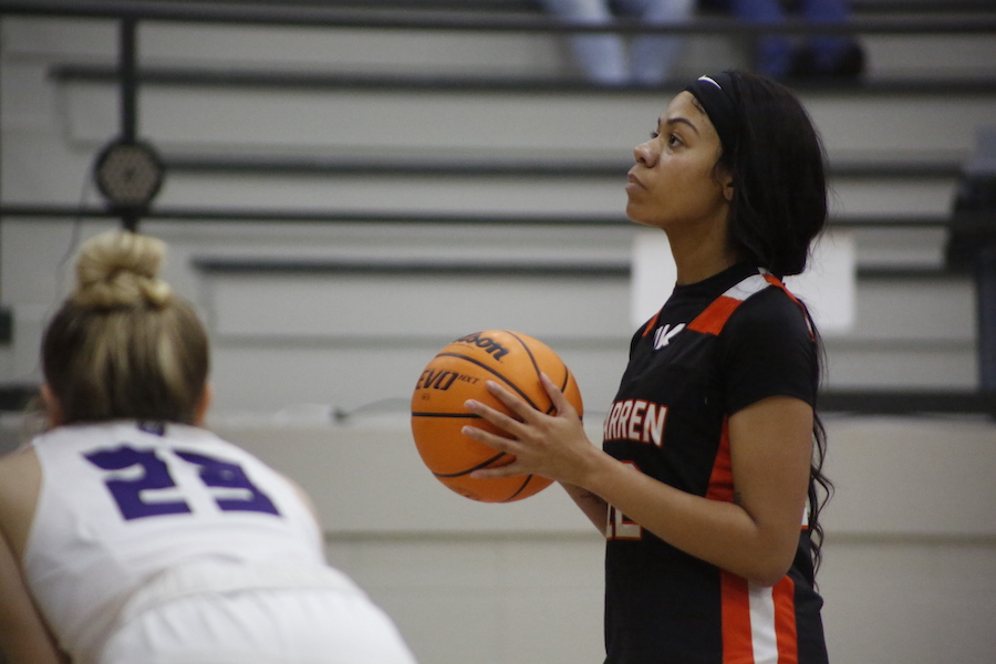 A girl holding onto a basketball in the air