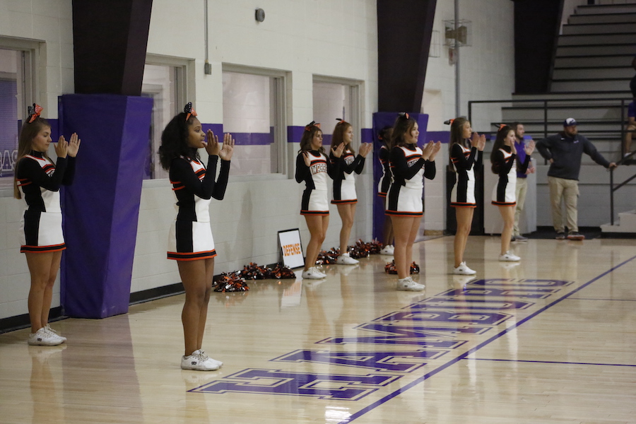 A group of cheerleaders standing in front of the audience.