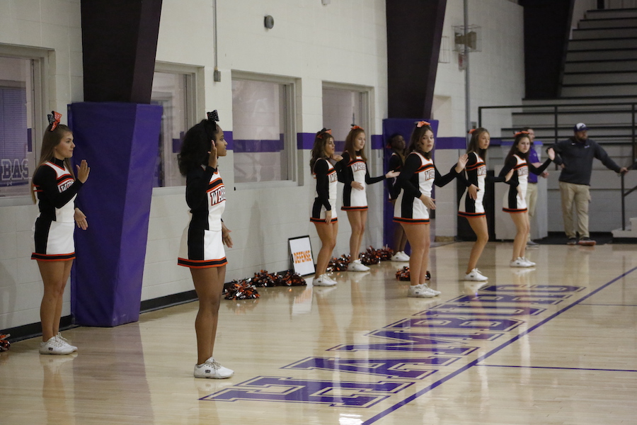 A group of cheerleaders standing in front of the audience.