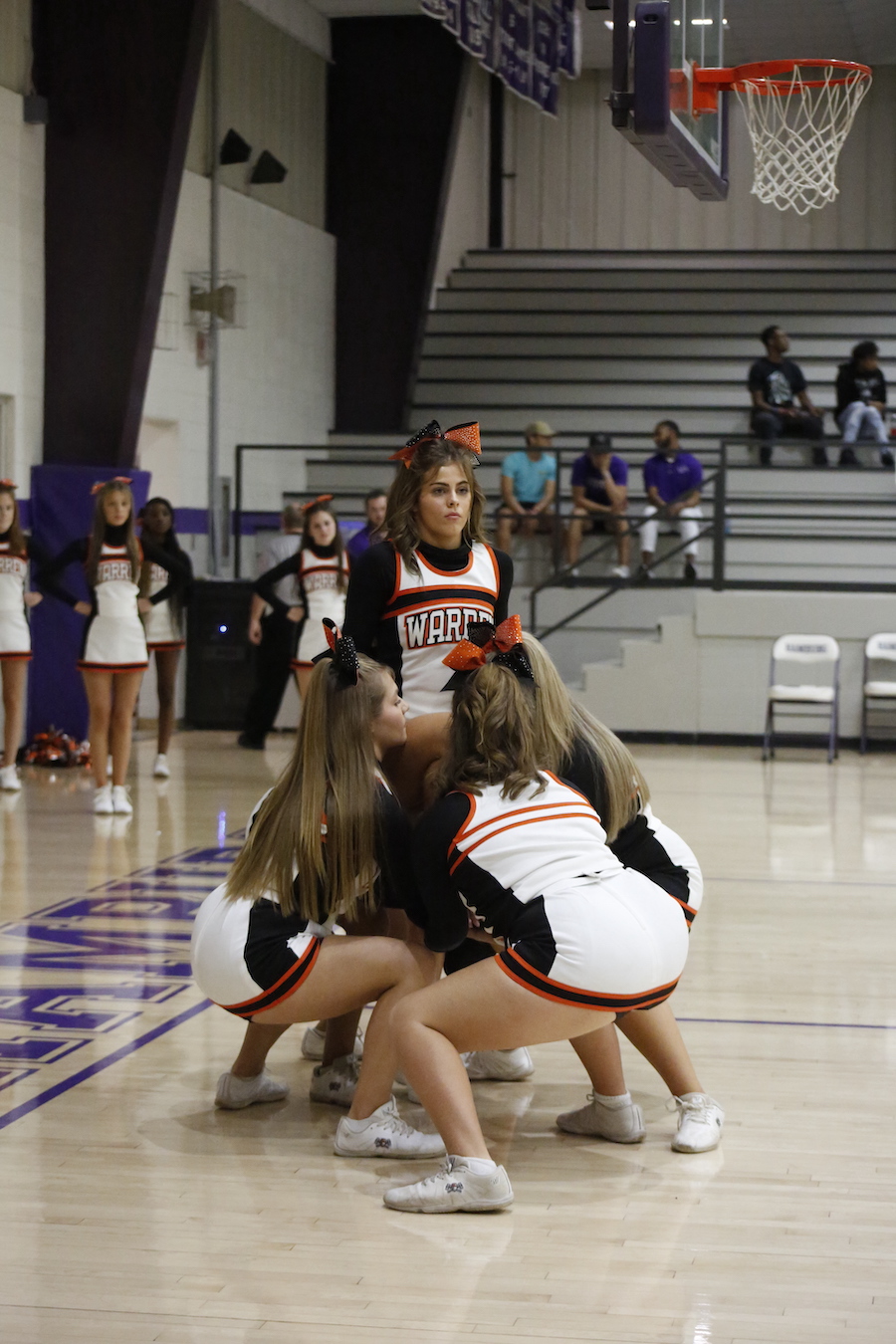 A group of cheerleaders are standing on the court