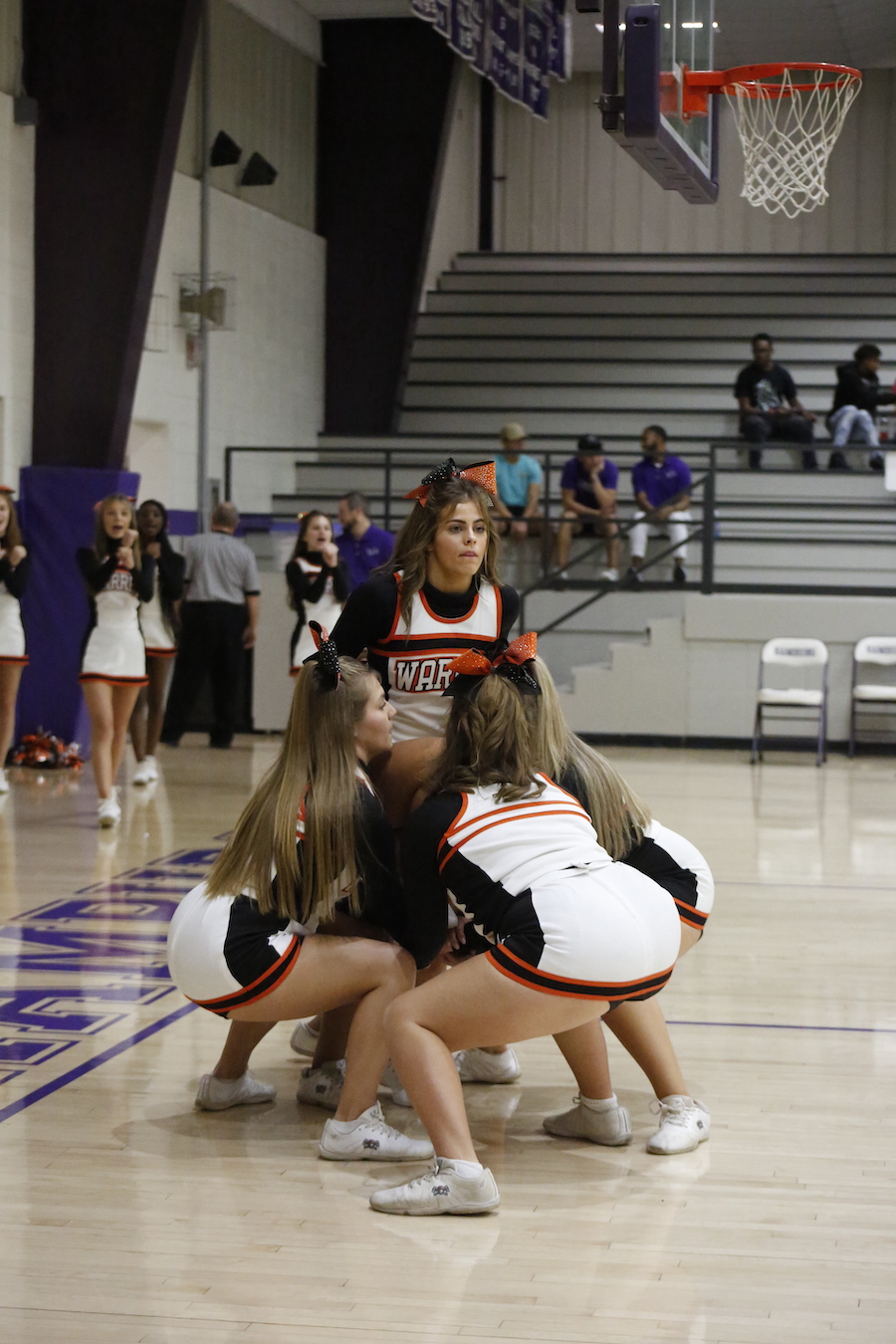 A group of cheerleaders are performing on the court.