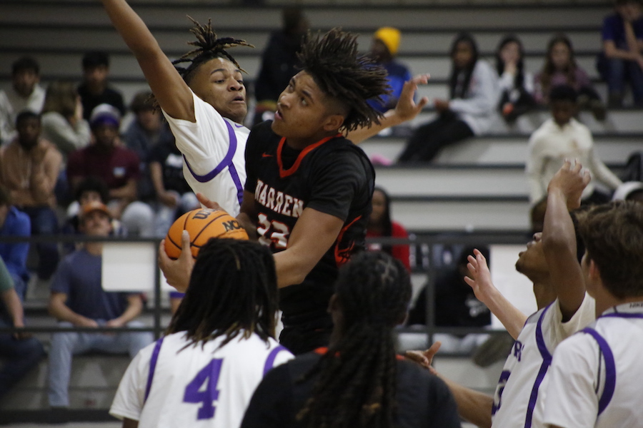 A group of people playing basketball in front of an audience.