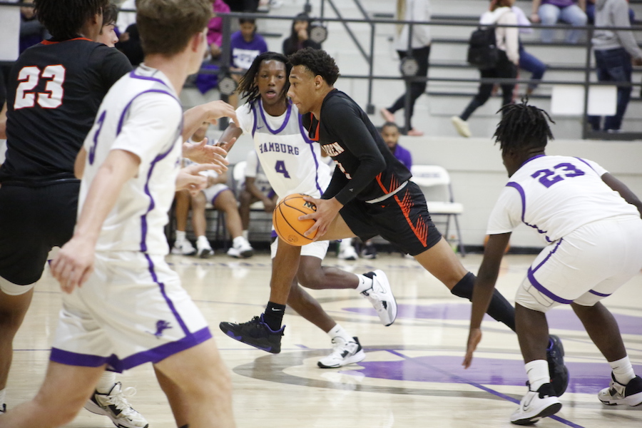 A group of young men playing basketball on a court.