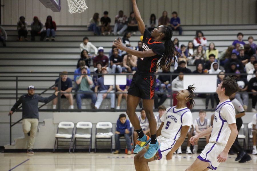 A basketball player is jumping in the air to dunk.