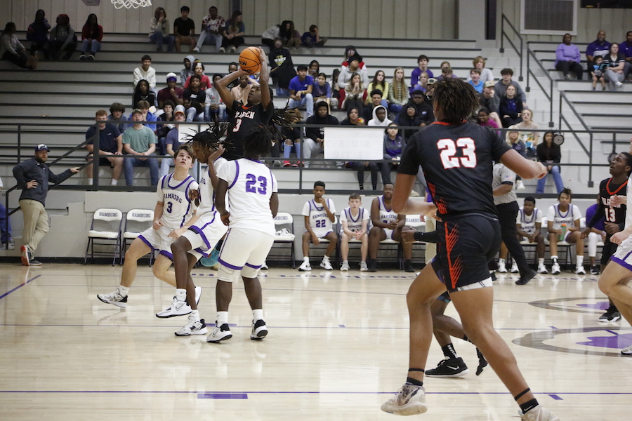 A group of people playing basketball on a court.