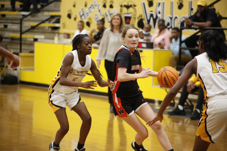 A group of young people playing basketball on a court.