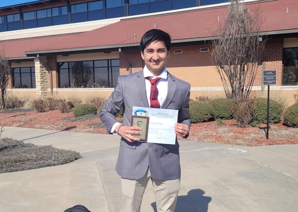 A man in suit and tie holding up a paper.