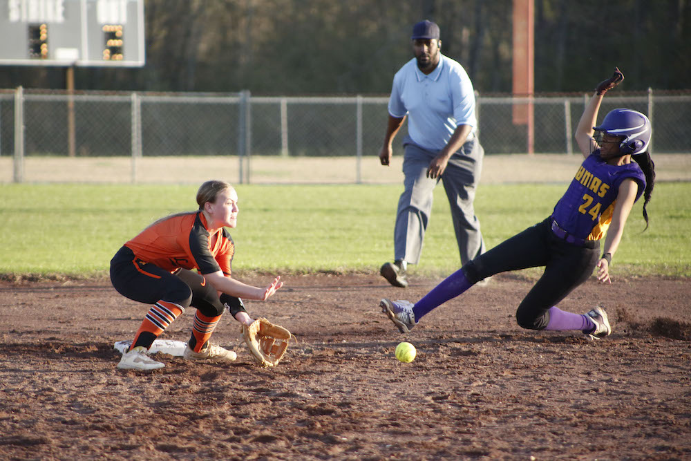 A softball player is running to catch the ball.