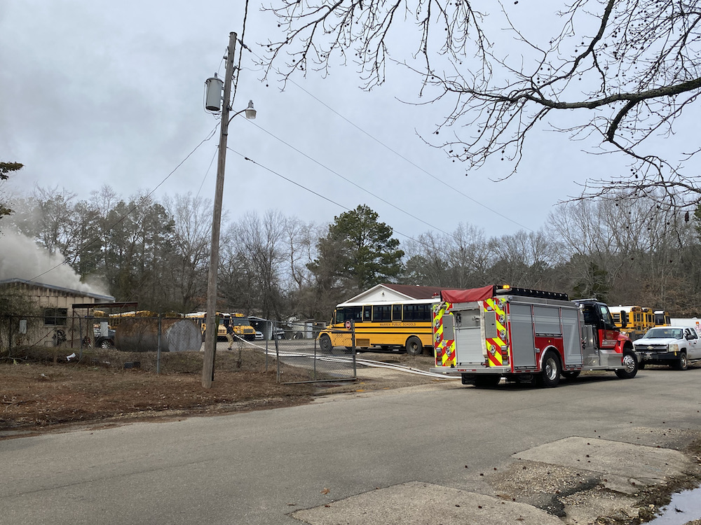 A fire truck is parked in front of a school bus.