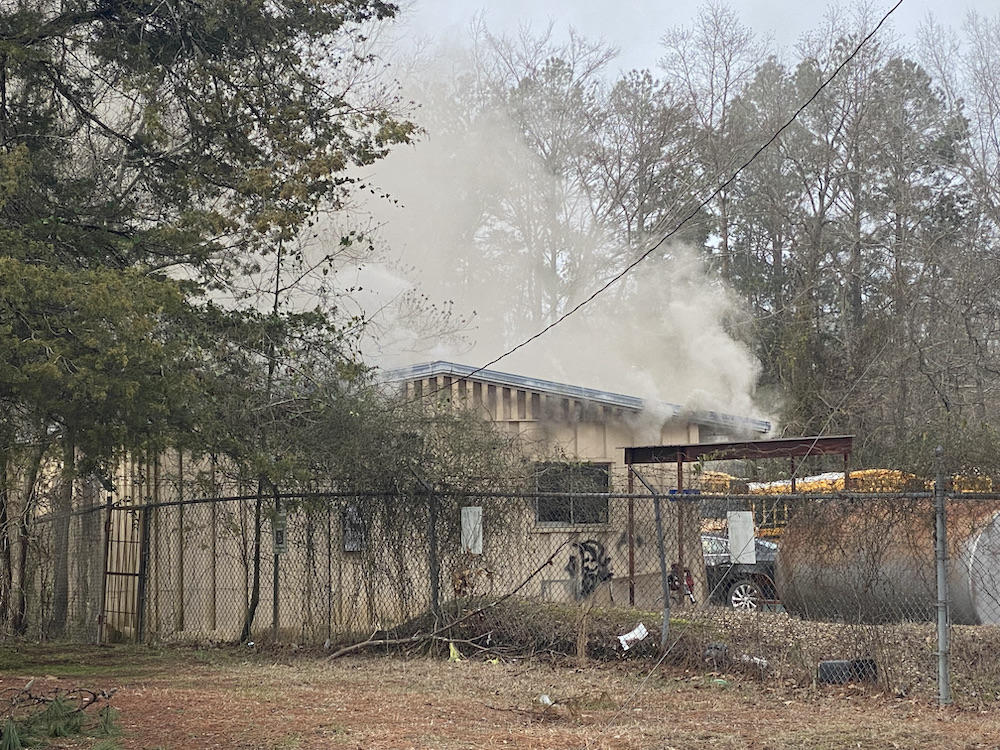A fire that is burning in the background of a building.