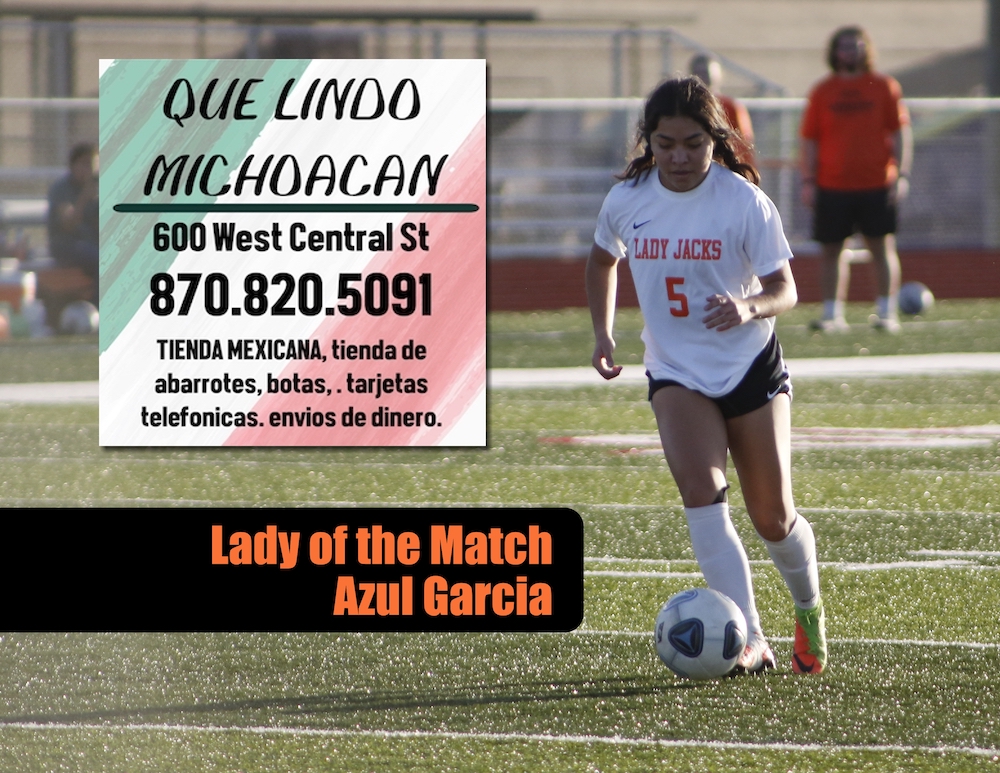 A girl is playing soccer on the field.