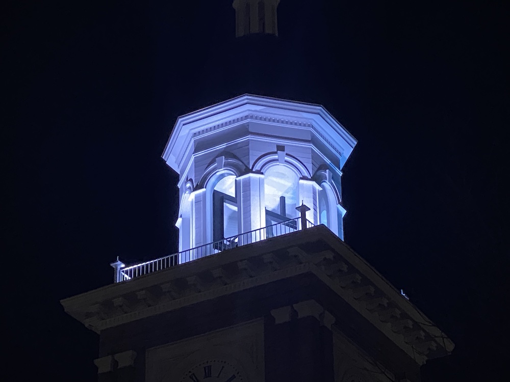 A building with a clock tower lit up at night.