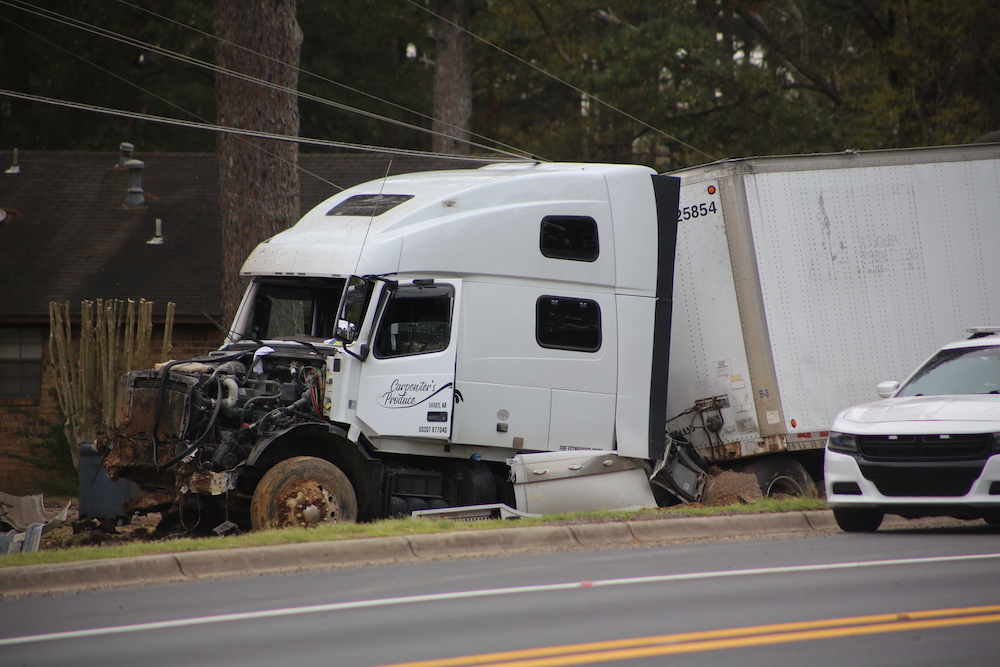 A white truck that has been smashed to pieces.