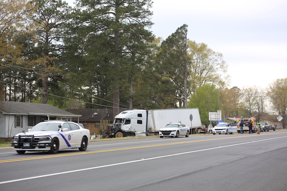 A police car and other vehicles on the side of the road.