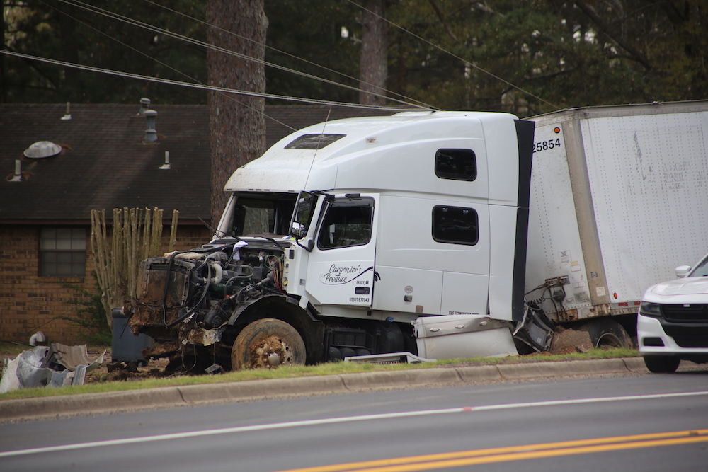 A white truck that has been smashed in to pieces.